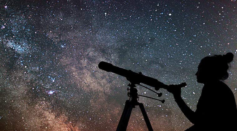 Eine Frau beobachtet den Sternenhimmel bei Nacht